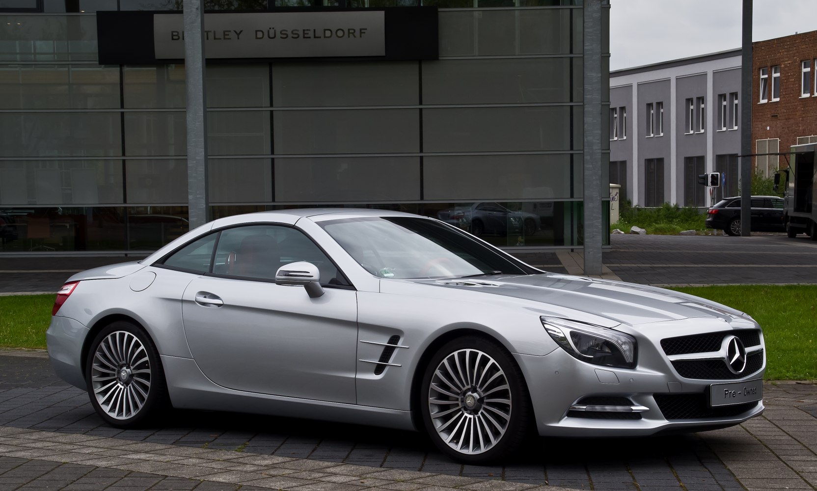 Silver sports coupe with aerodynamic design and distinctive alloy wheels.