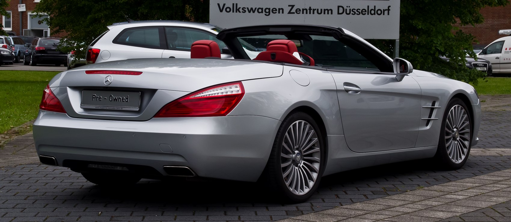 Rear view of silver convertible with red interior and stylish taillights