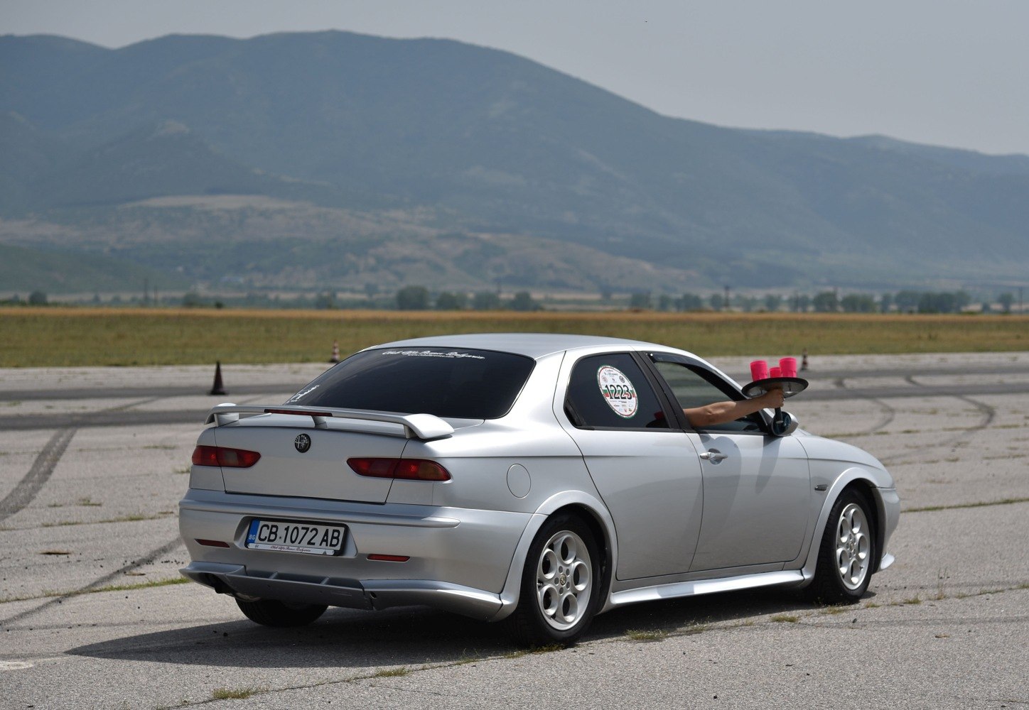 Silver sedan rear side with spoiler and alloy wheels