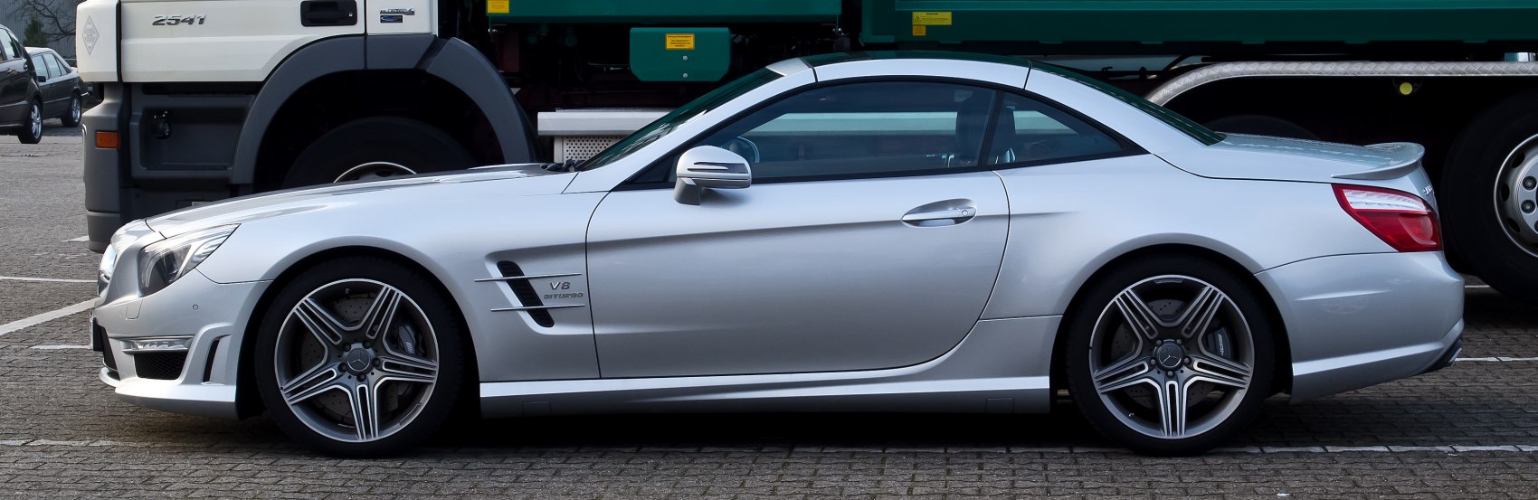 Silver coupe side view with V8 badge and alloy wheels