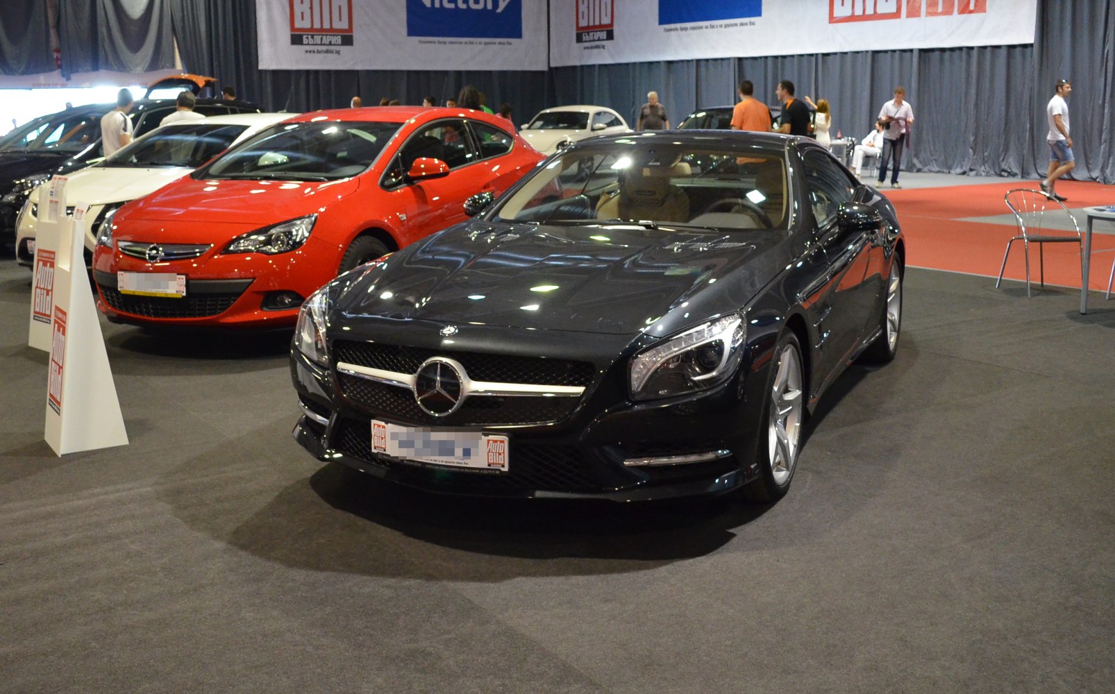 Sleek black front view with prominent grille and headlights