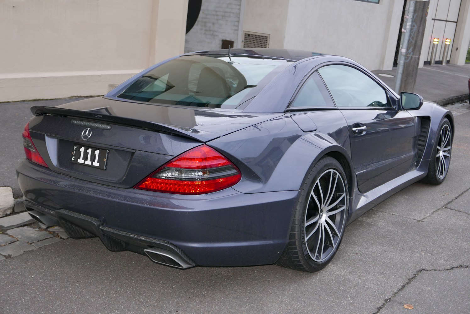 Rear view of coupe with spoiler and multi-spoke wheels
