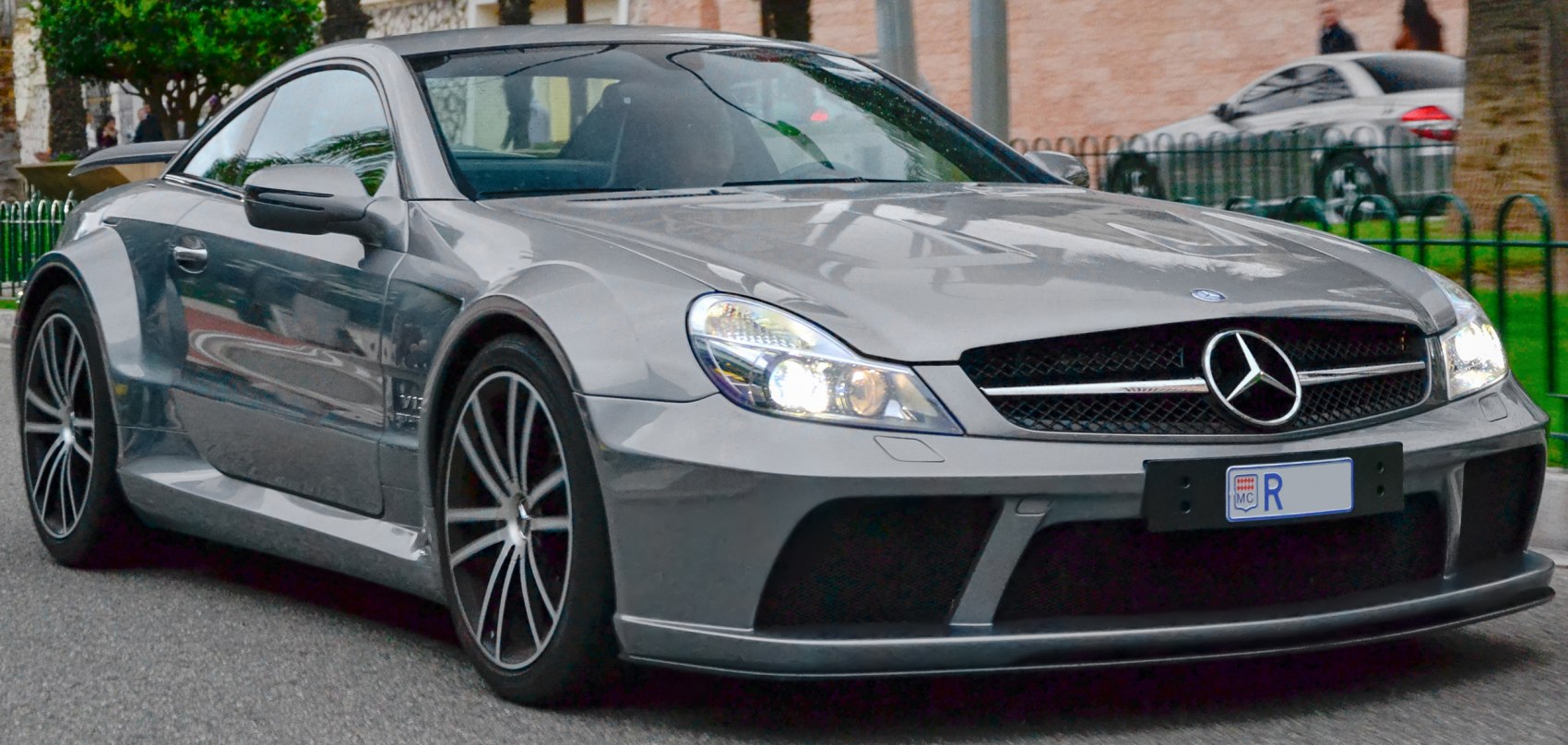 Front view of aggressive styled coupe with V12 engine badge and sleek headlamps