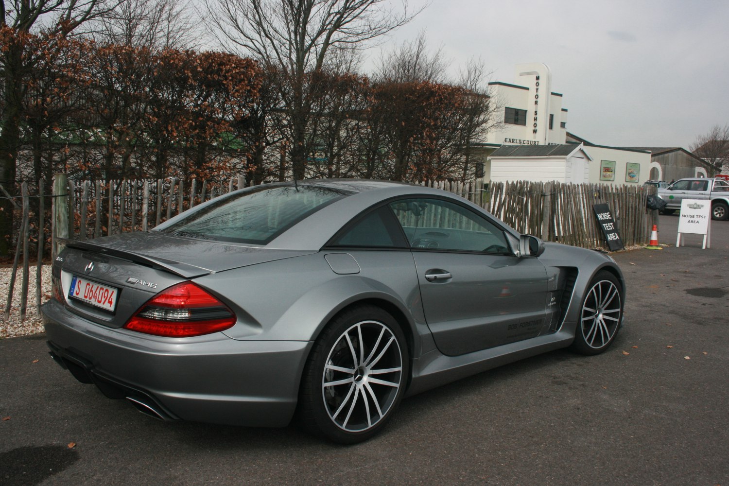 Rear and side profile of silver luxury coupe with spoiler and alloy wheels.