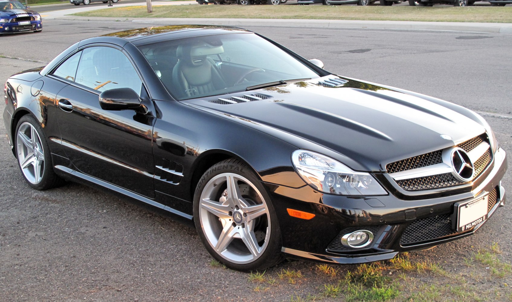 Front-side view of a sleek black sports convertible with alloy wheels
