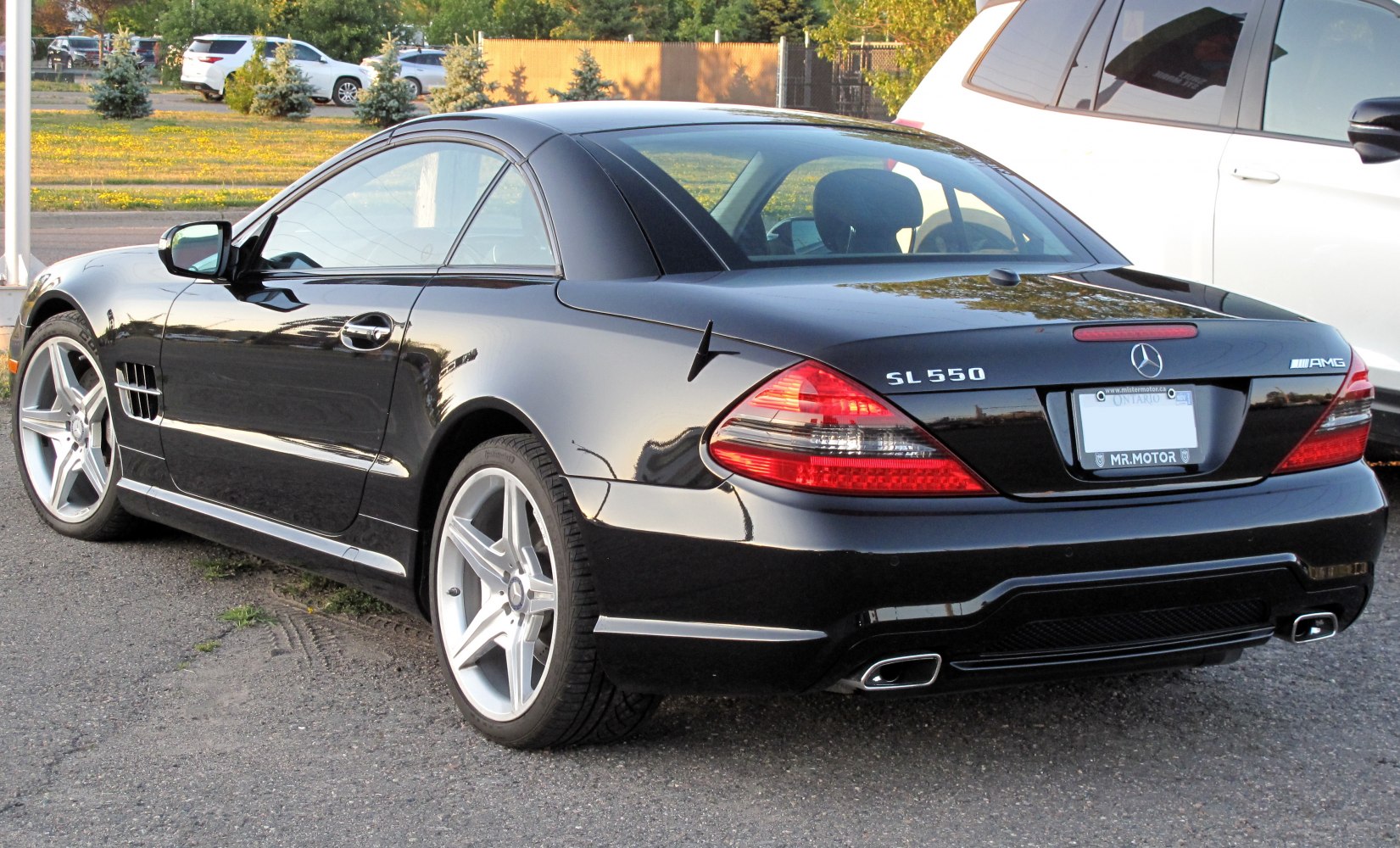 Sleek black luxury coupe rear side with AMG wheels and dual exhaust