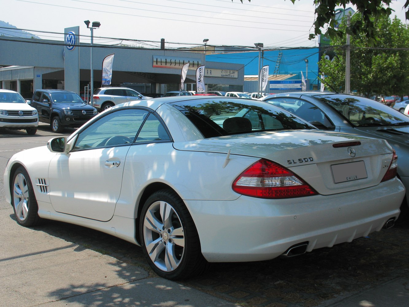Rear and side view of white luxury coupe with alloy wheels and sporty design.