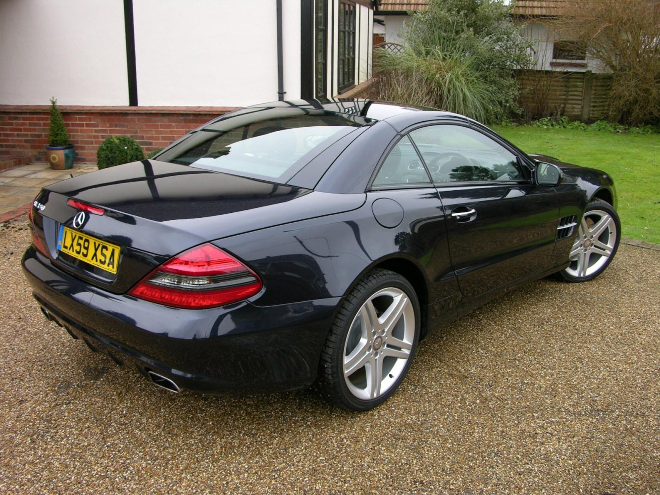 Rear and side profile of a black coupe with alloy wheels and distinct taillights