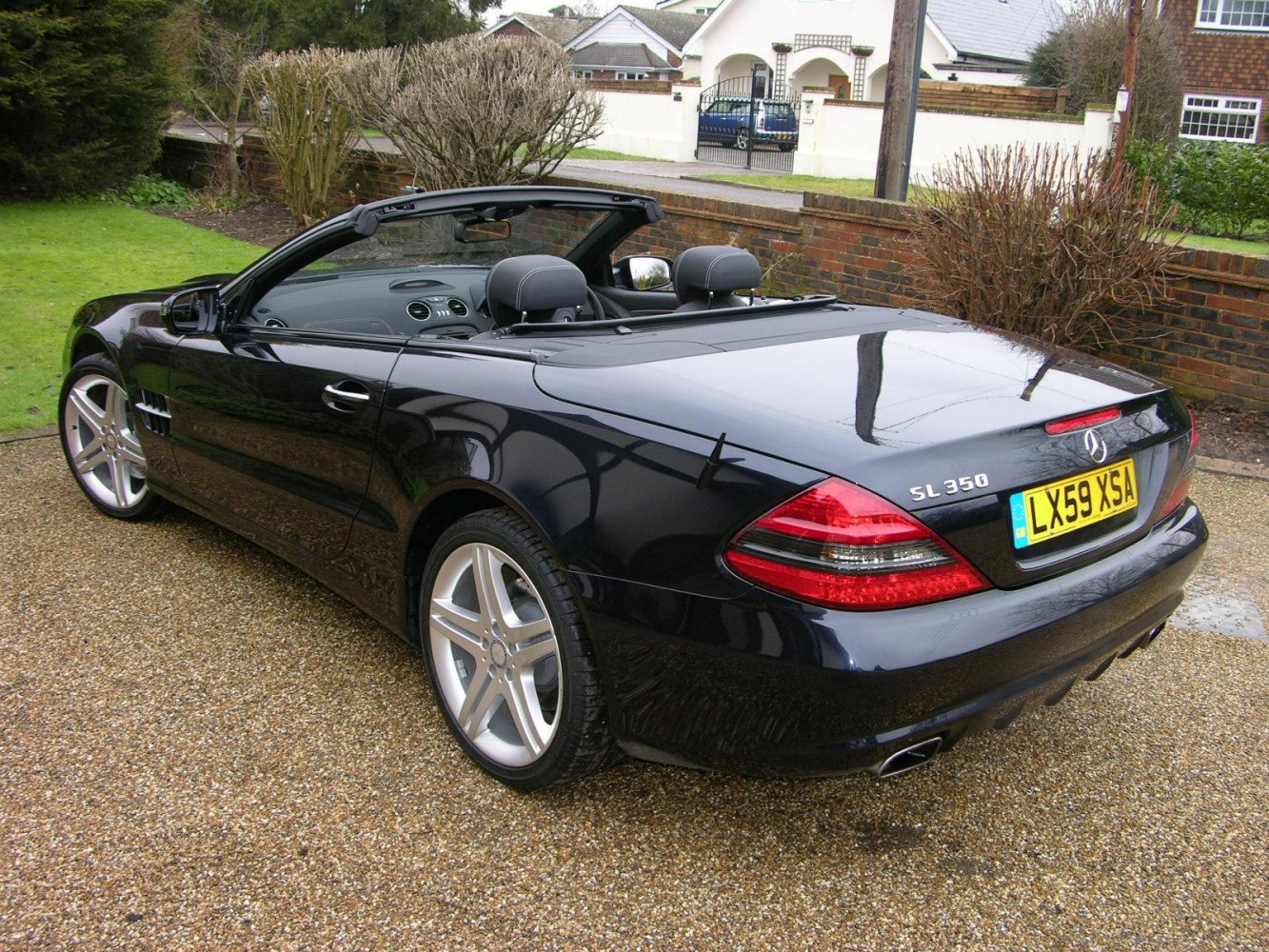 Convertible rear and side view with highlighted tail lights and alloy wheels