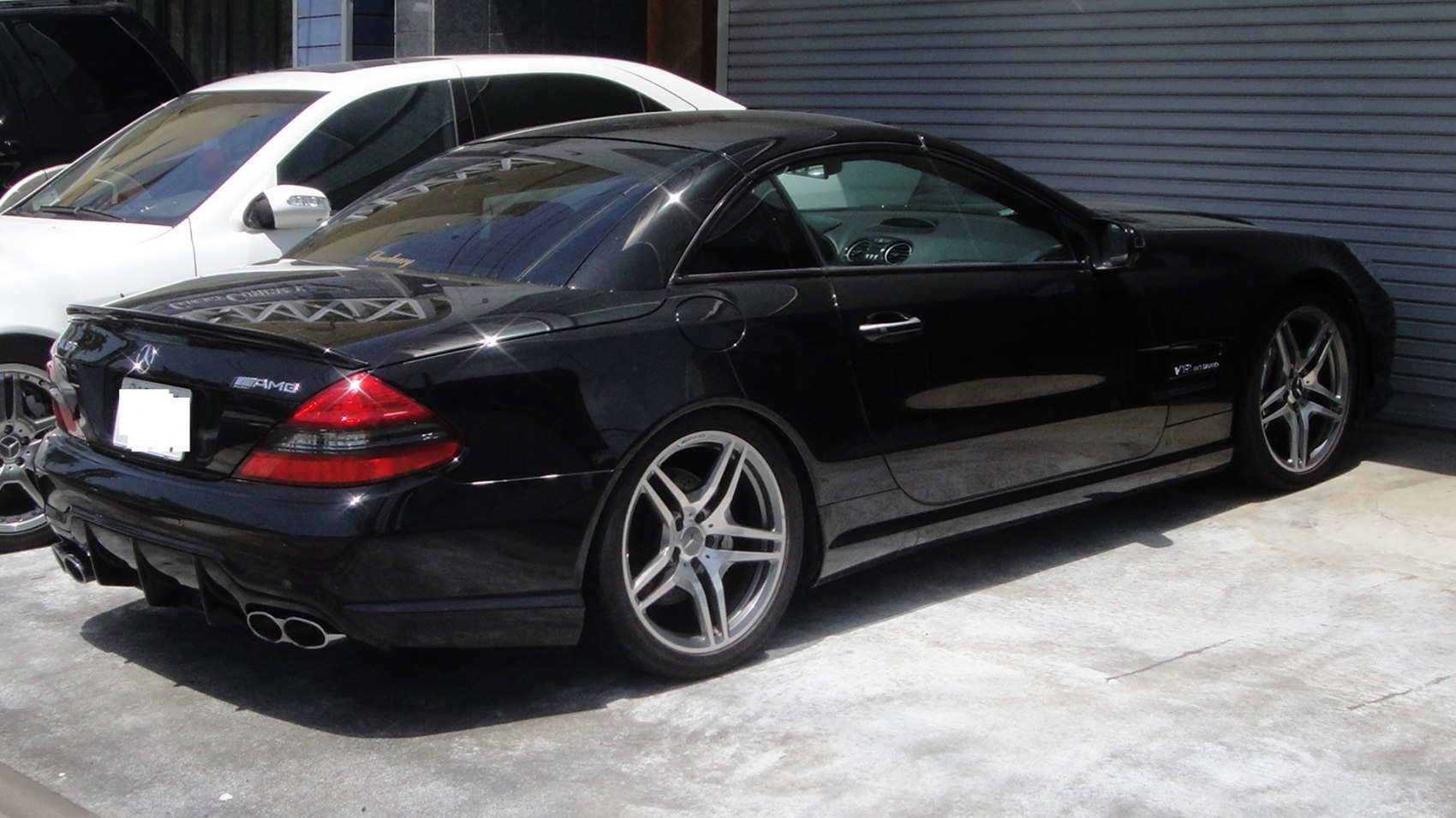 Black luxury sports coupe with AMG and V12 BiTurbo badges, quad exhaust and alloy wheels.