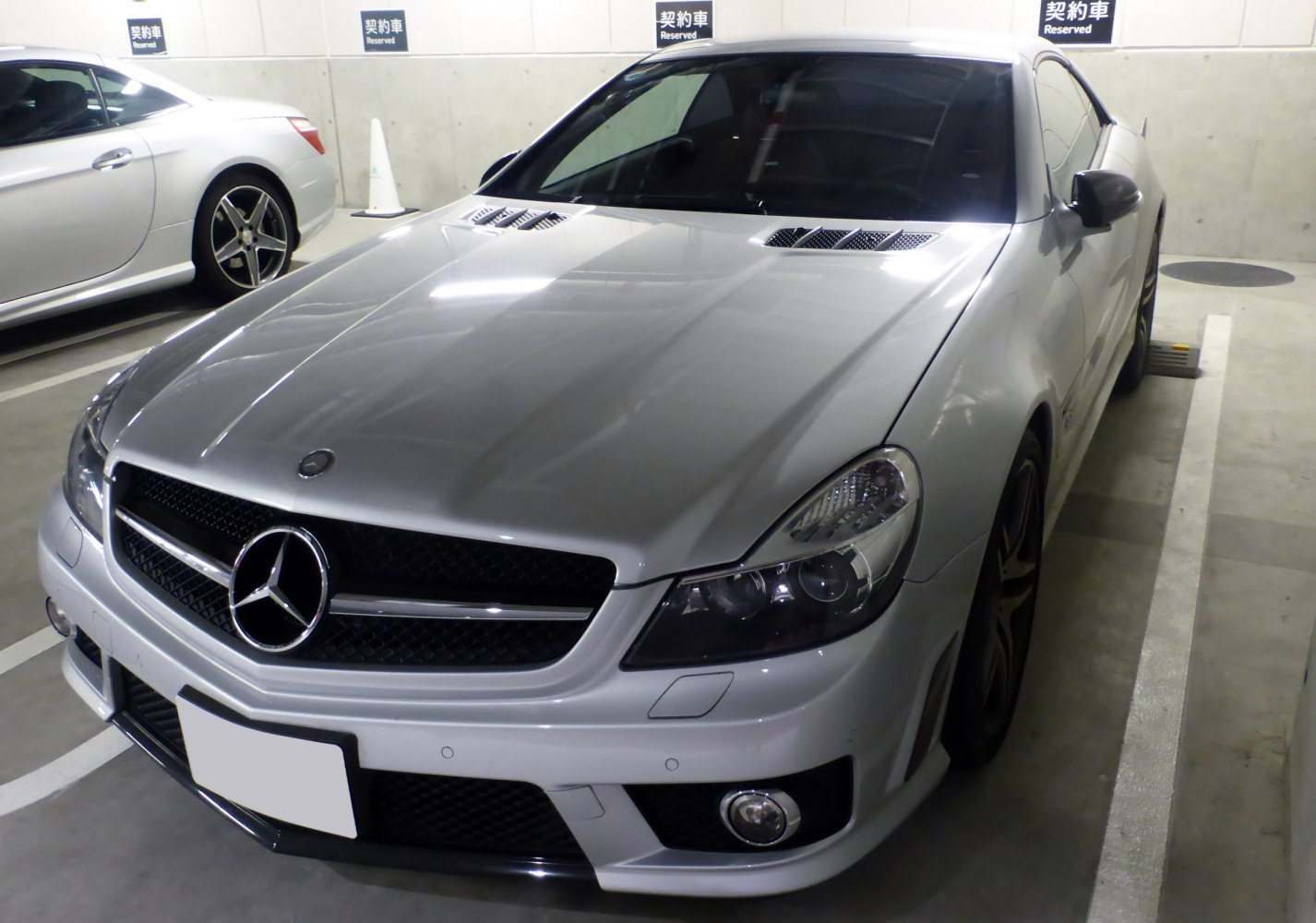 Front grille, dual projector headlights, and hood vents on a luxury coupe