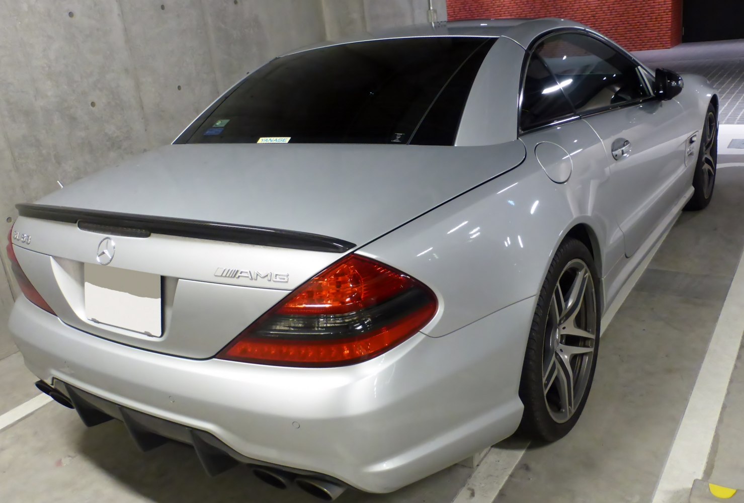Rear and side view of a silver sports coupe with AMG badge and distinctive tail lights