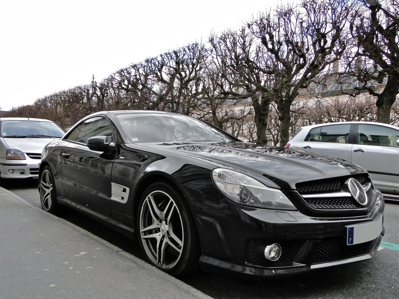 Black luxury coupe front-side view with alloy wheels and distinctive grille.