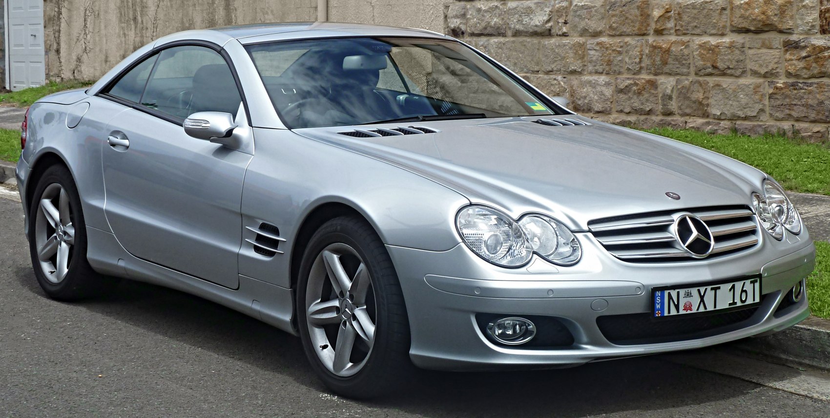 Silver coupe with dual headlamps and alloy wheels from front side angle