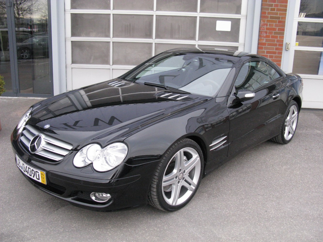 Front-side view of black coupe with sharp headlights and alloy wheels