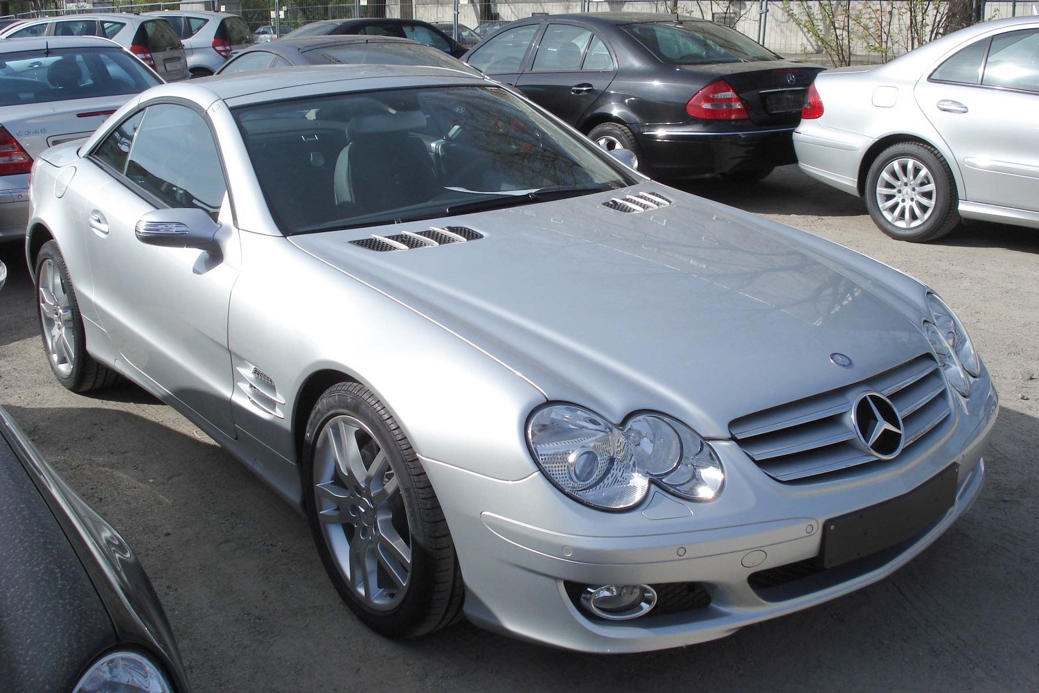 Silver sports coupe with hood vents and dual rounded headlights