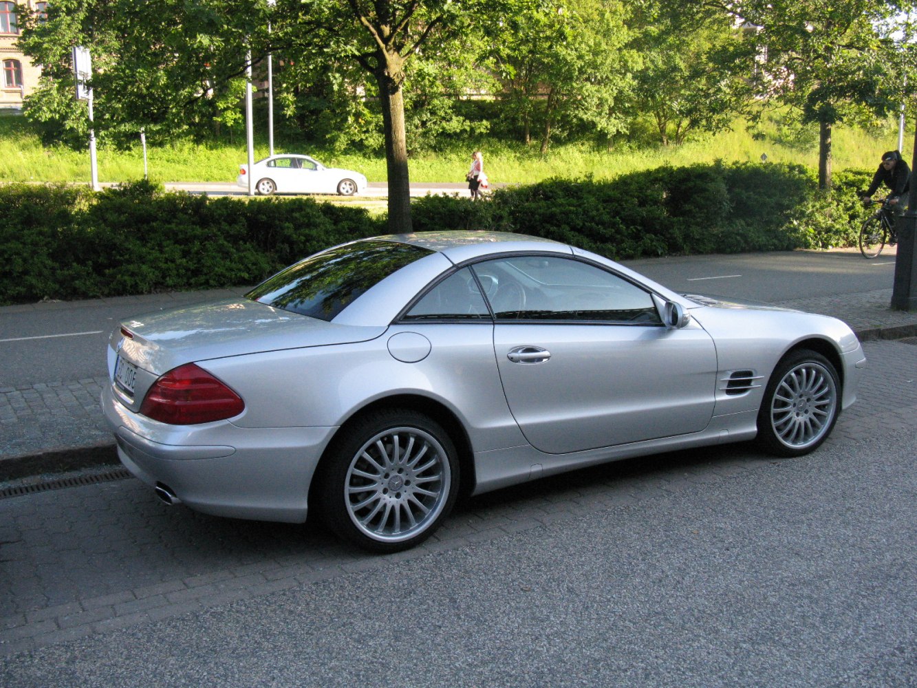 Silver coupe with hardtop roof and alloy wheels parked on urban street