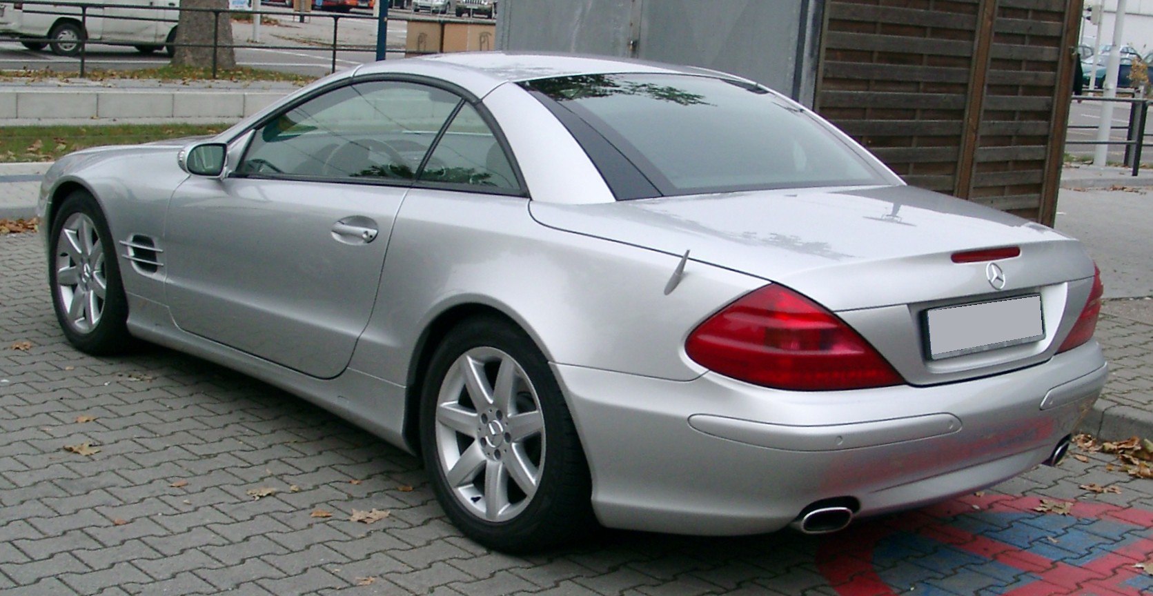 Silver two-door coupe with rear spoiler and dual exhaust pipes