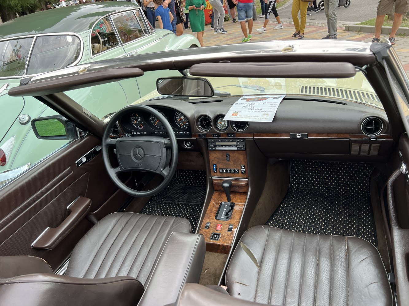 Convertible interior with wood trim, analog gauges, leather seats, and round air vents