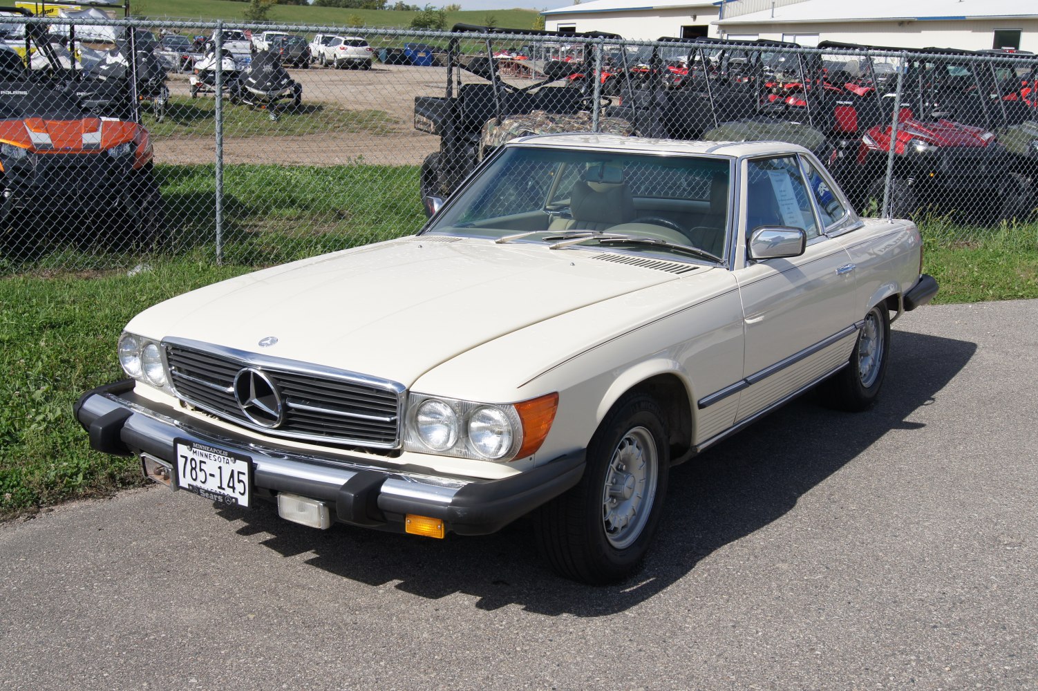 White luxury coupe with chrome grille and round headlights