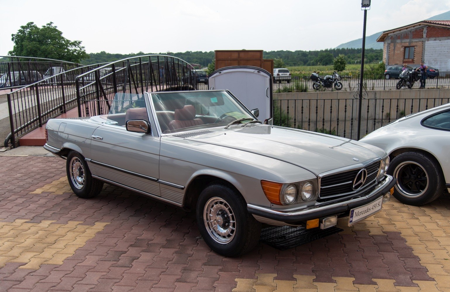 Convertible with chrome wheels, round headlights, and vintage design