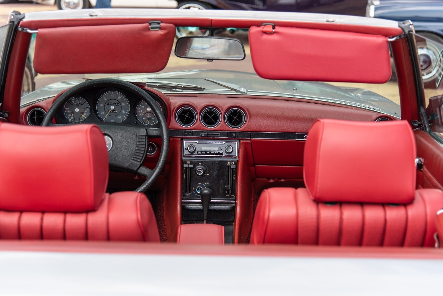 Red convertible interior with vintage dashboard and analog instruments
