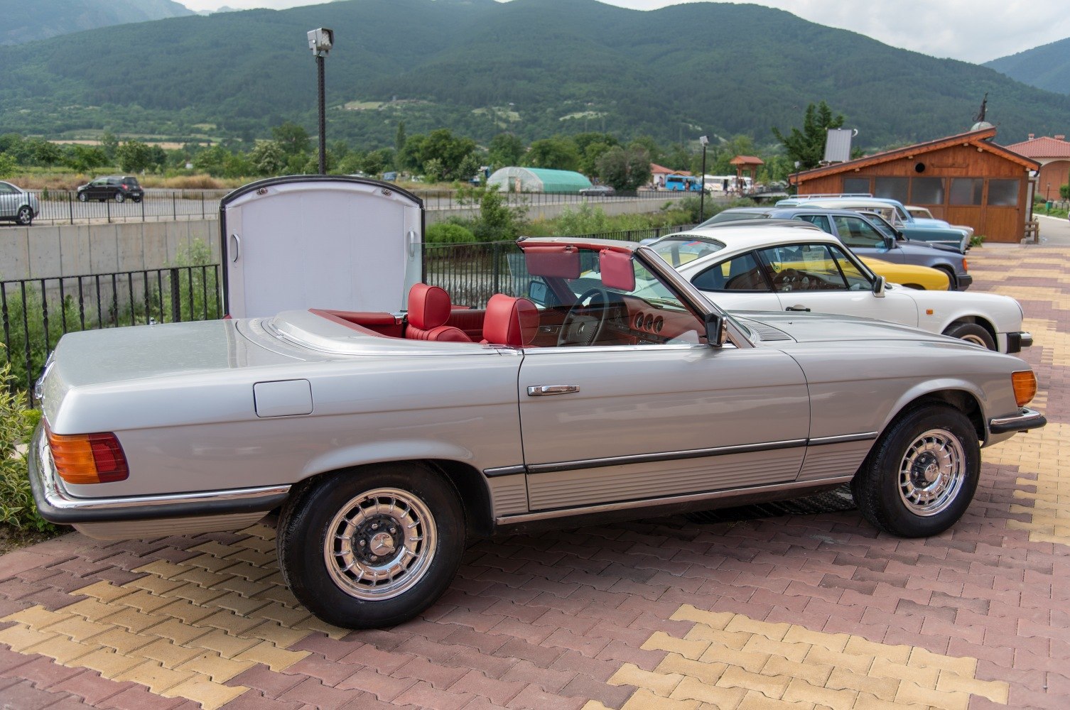 Silver convertible with red leather seats and chrome wheels