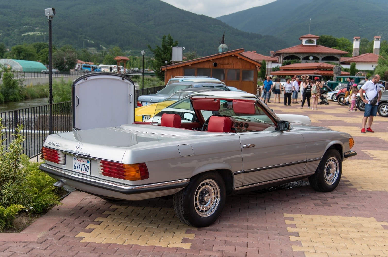 Silver classic convertible with distinctive red leather interior and open soft top