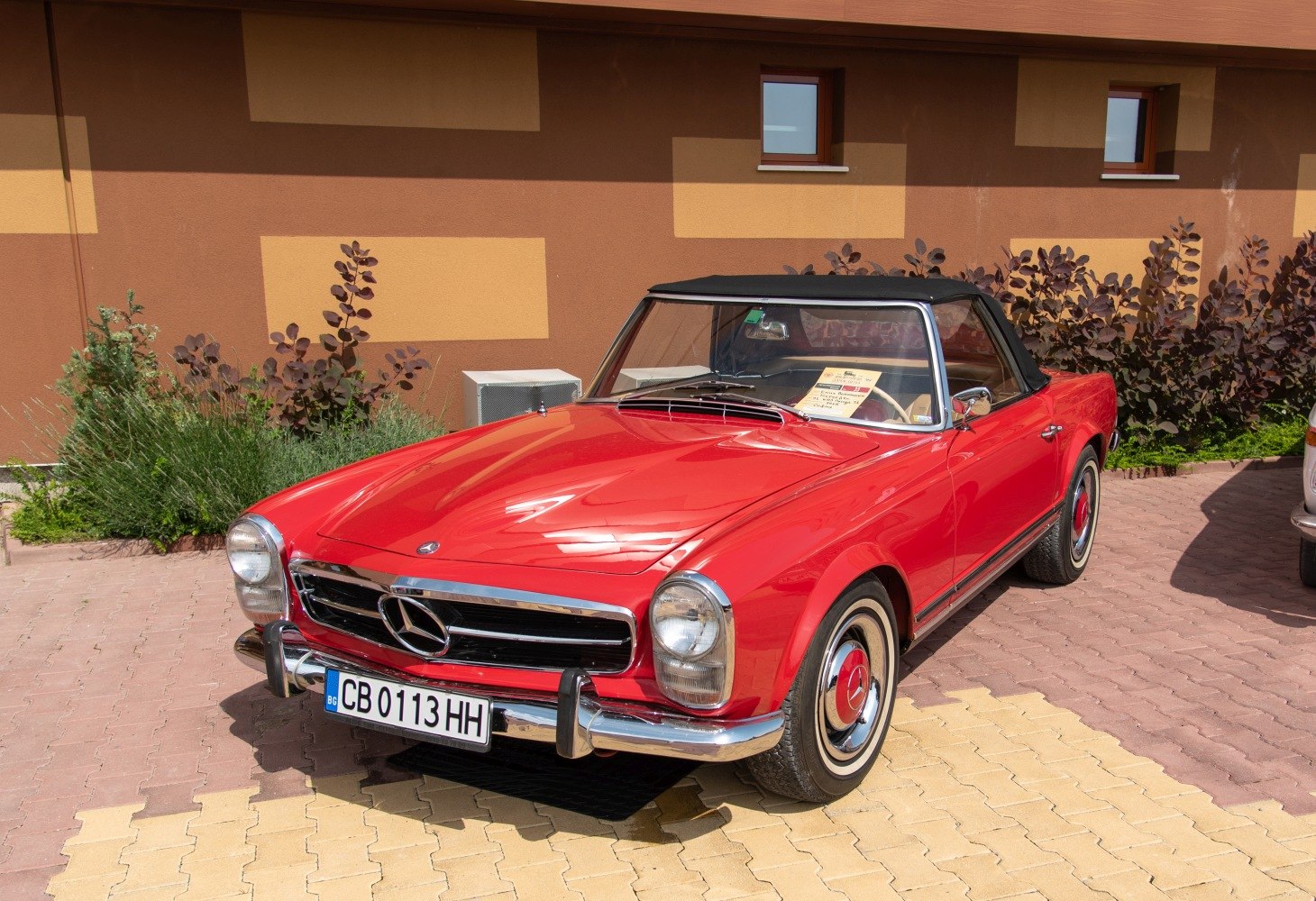 Red vintage convertible with black soft top and chrome details