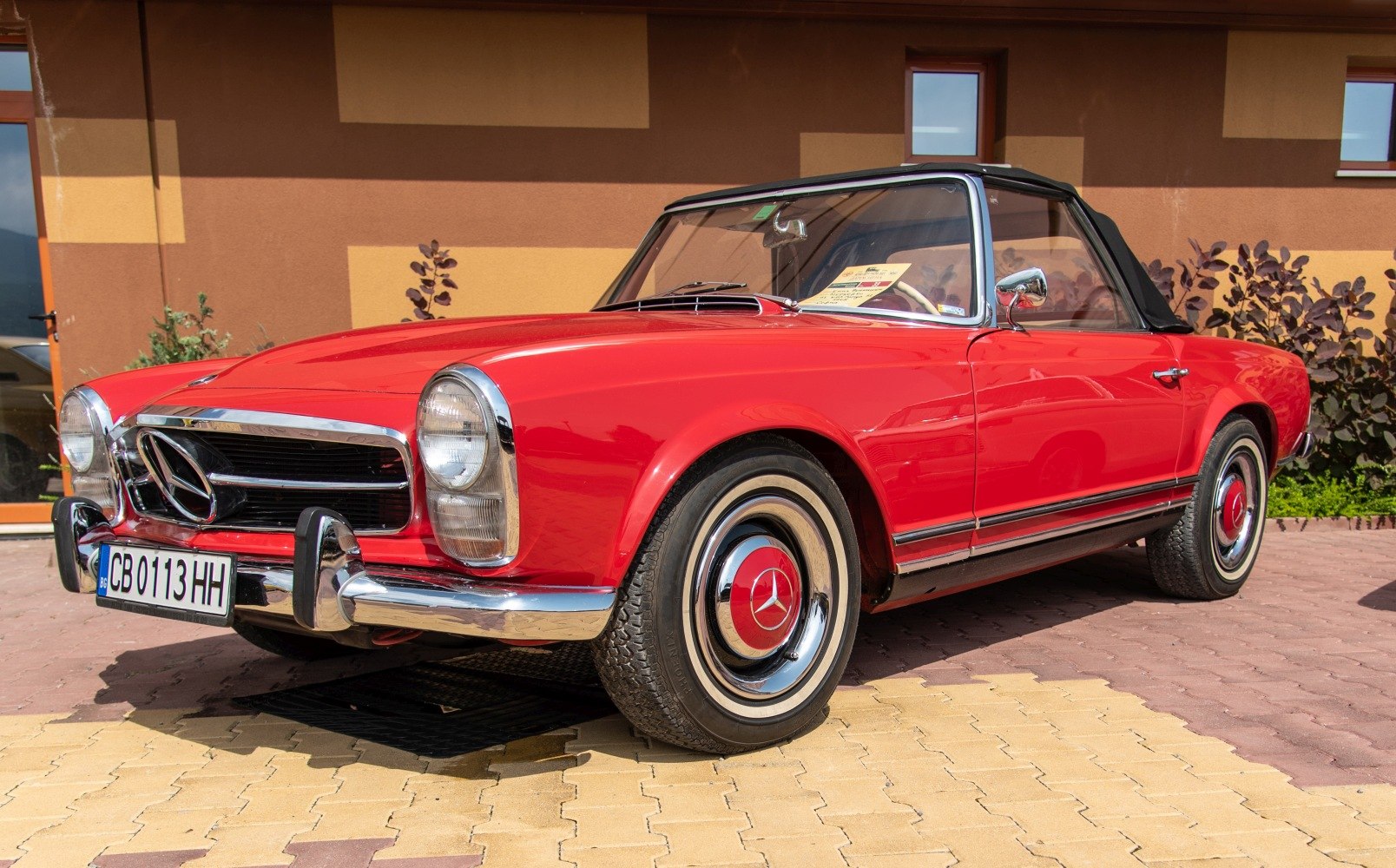 Vintage convertible with rounded headlights and chrome grille
