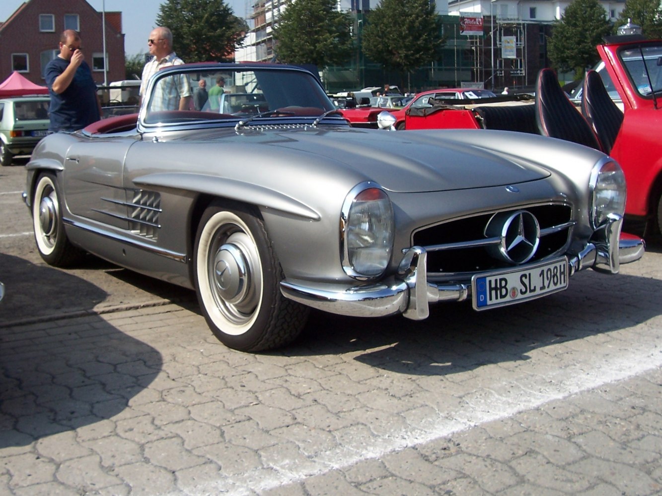 Silver vintage convertible with front grille and chrome bumpers