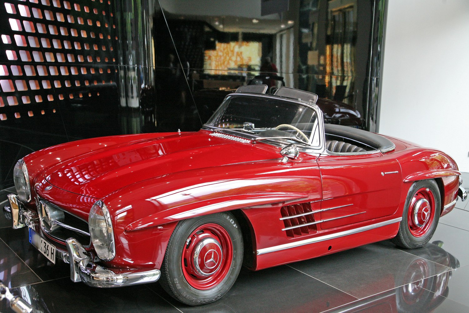 Red convertible sports car with chrome trim and side vents