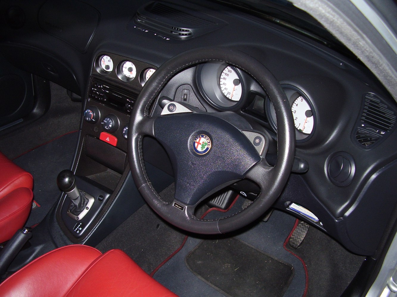 Dashboard and steering wheel with red leather seats interior