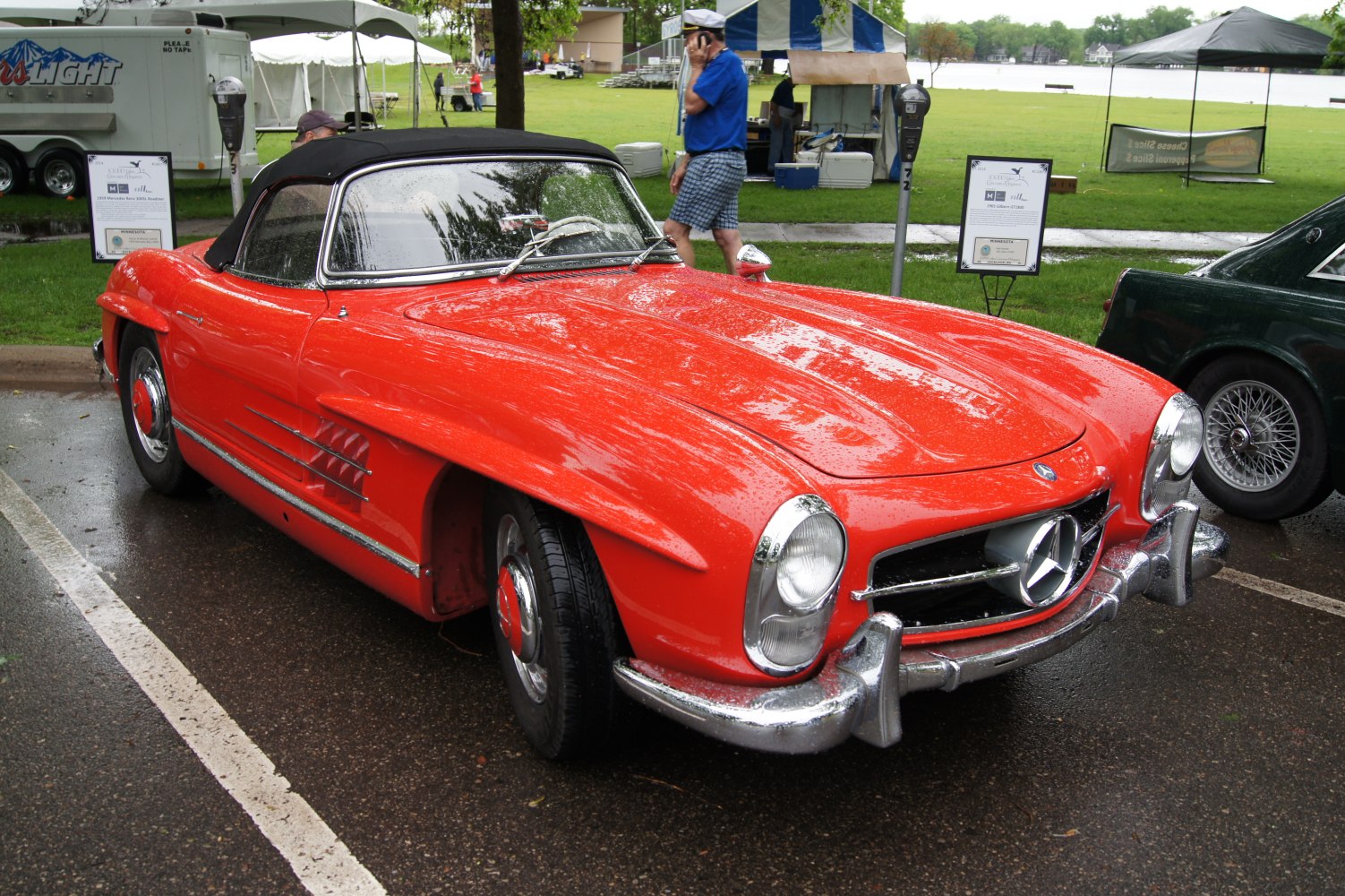 Red classic convertible with chrome grille and rounded headlights