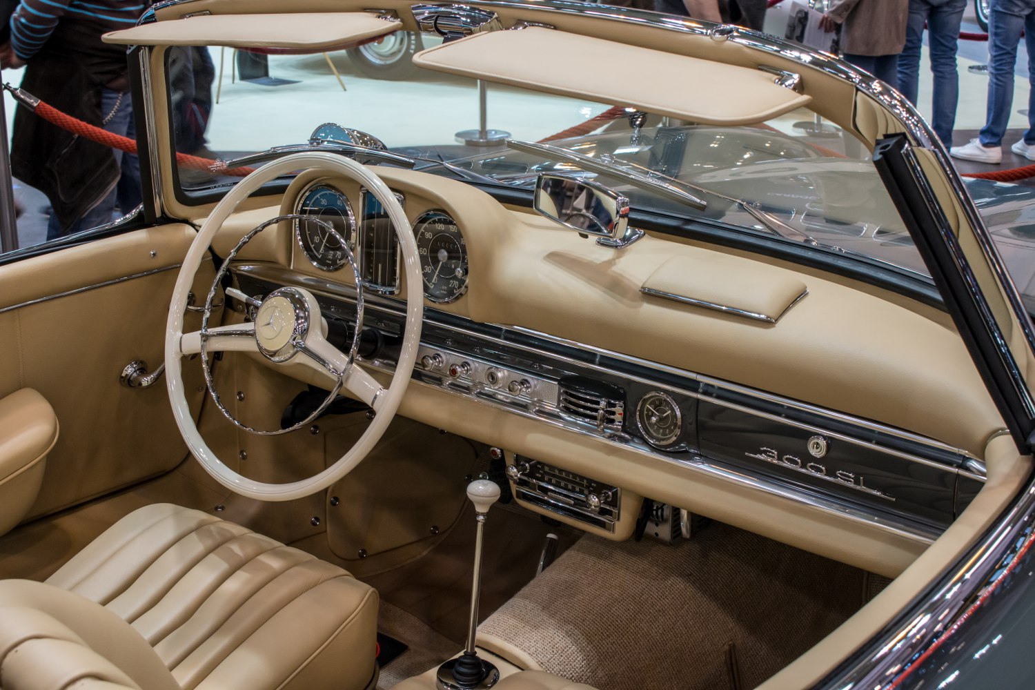 Vintage beige car interior with classic steering wheel and chrome-detailed dashboard