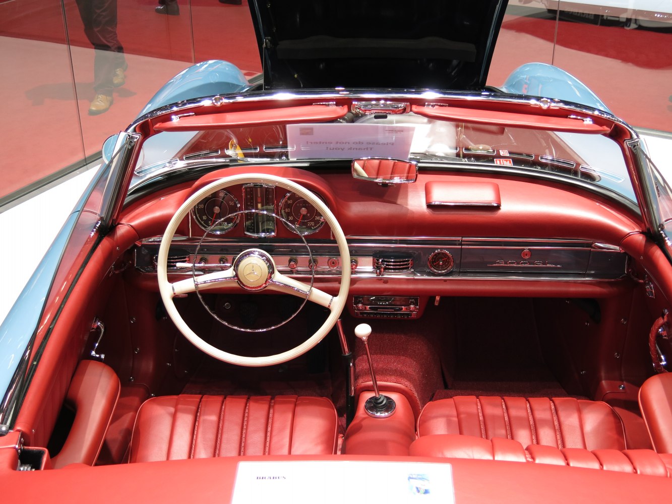 Red leather interior with white wooden steering wheel and retro dashboard.