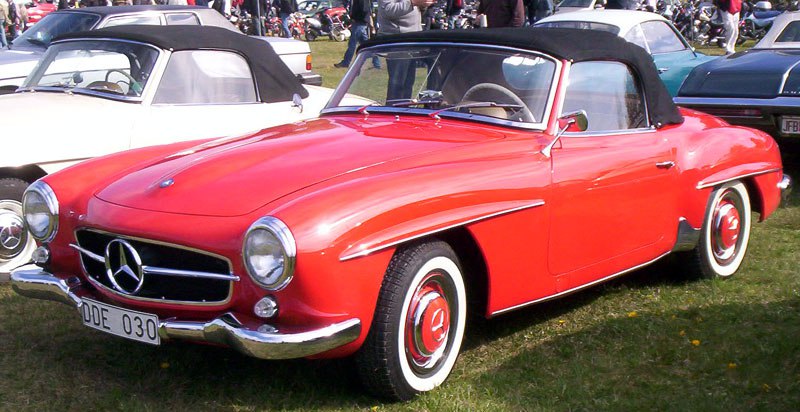 Red convertible roadster with rounded headlights and whitewall tires
