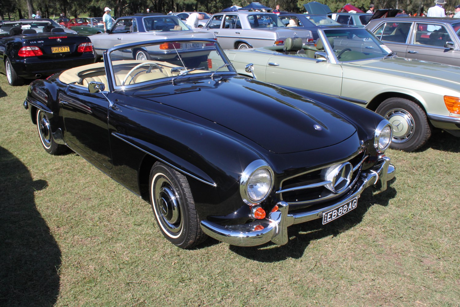 Black 1950s convertible roadster with round headlights and chrome bumpers