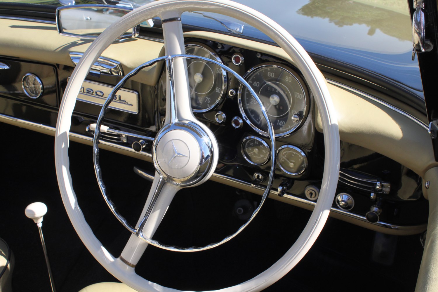 Vintage steering wheel and classic dashboard with analog gauges and chrome accents
