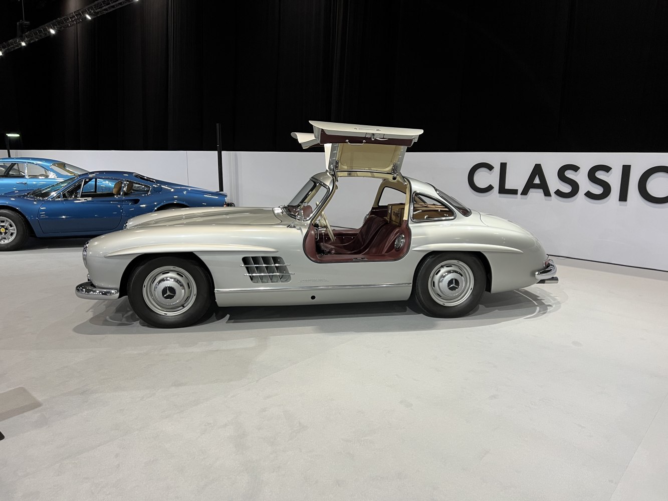 Side profile of a vintage coupe with iconic gullwing doors open