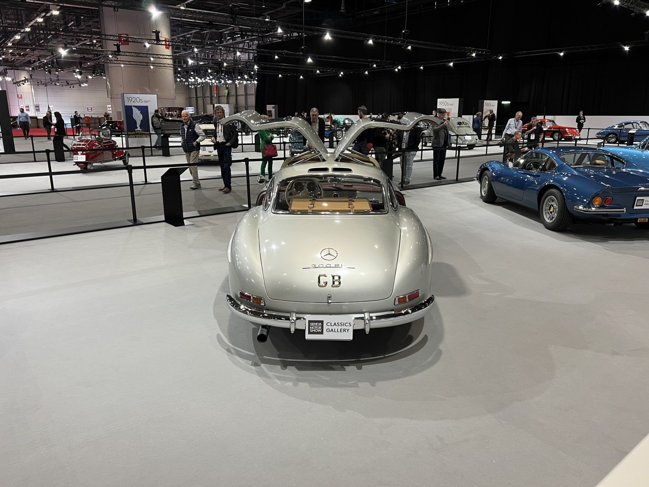 Silver vintage coupe with iconic gullwing doors open in exhibition