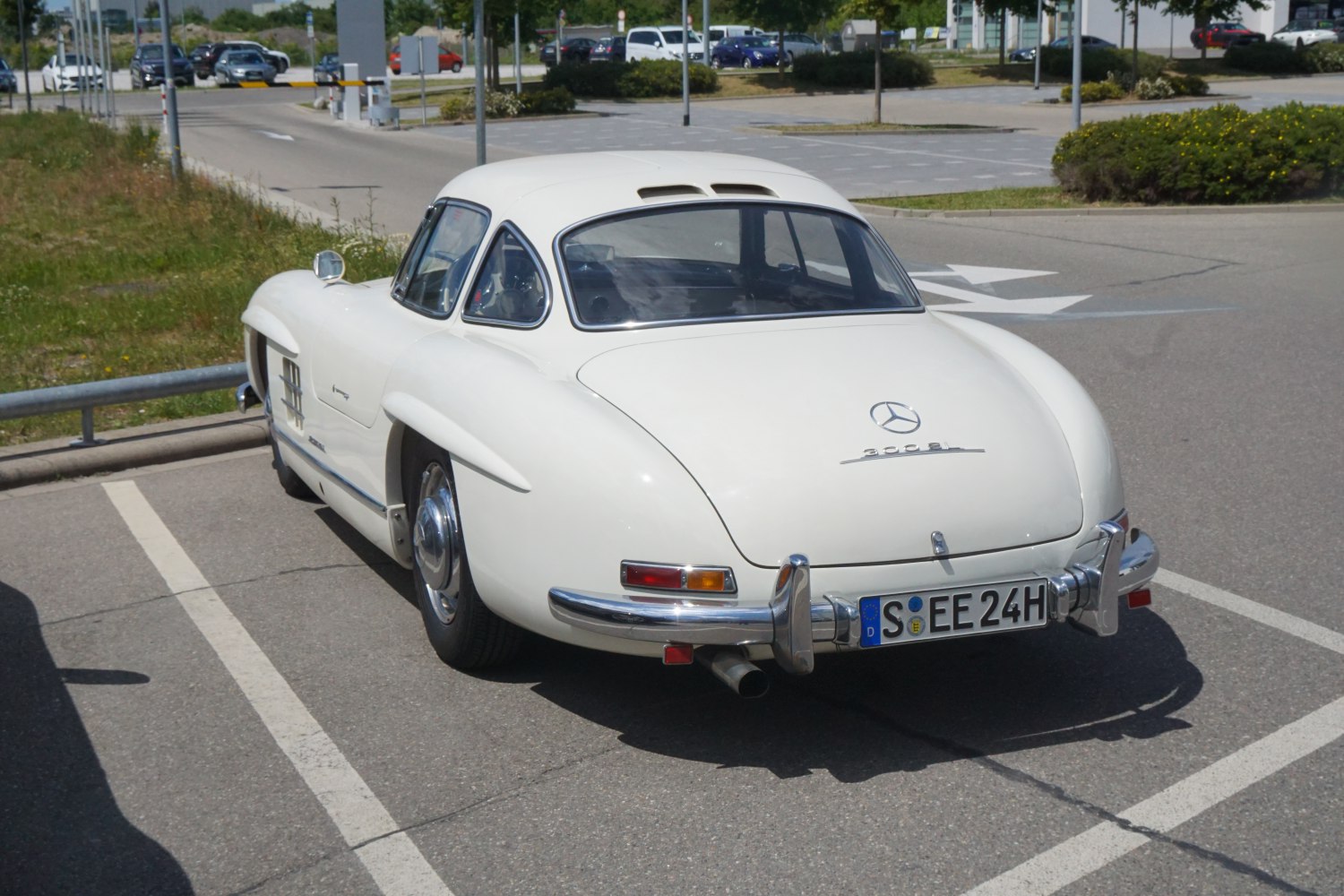 Curved fenders, vented hardtop roof, and chrome bumper on a vintage luxury coupe rear.