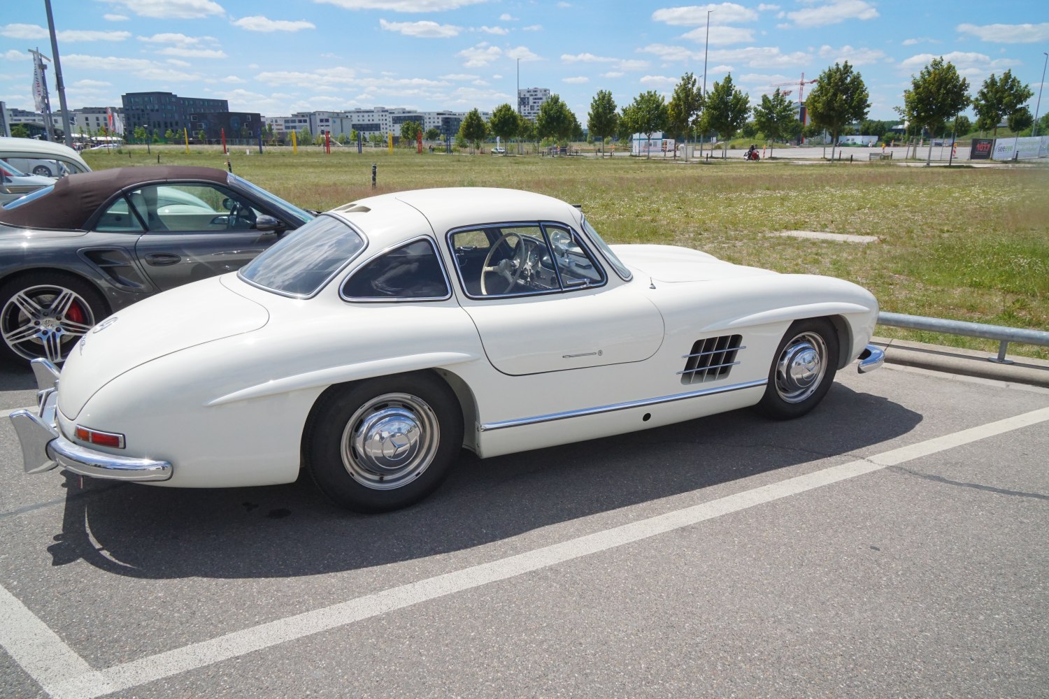 Vintage coupe with hardtop roof, side air vents, and chrome wheel covers