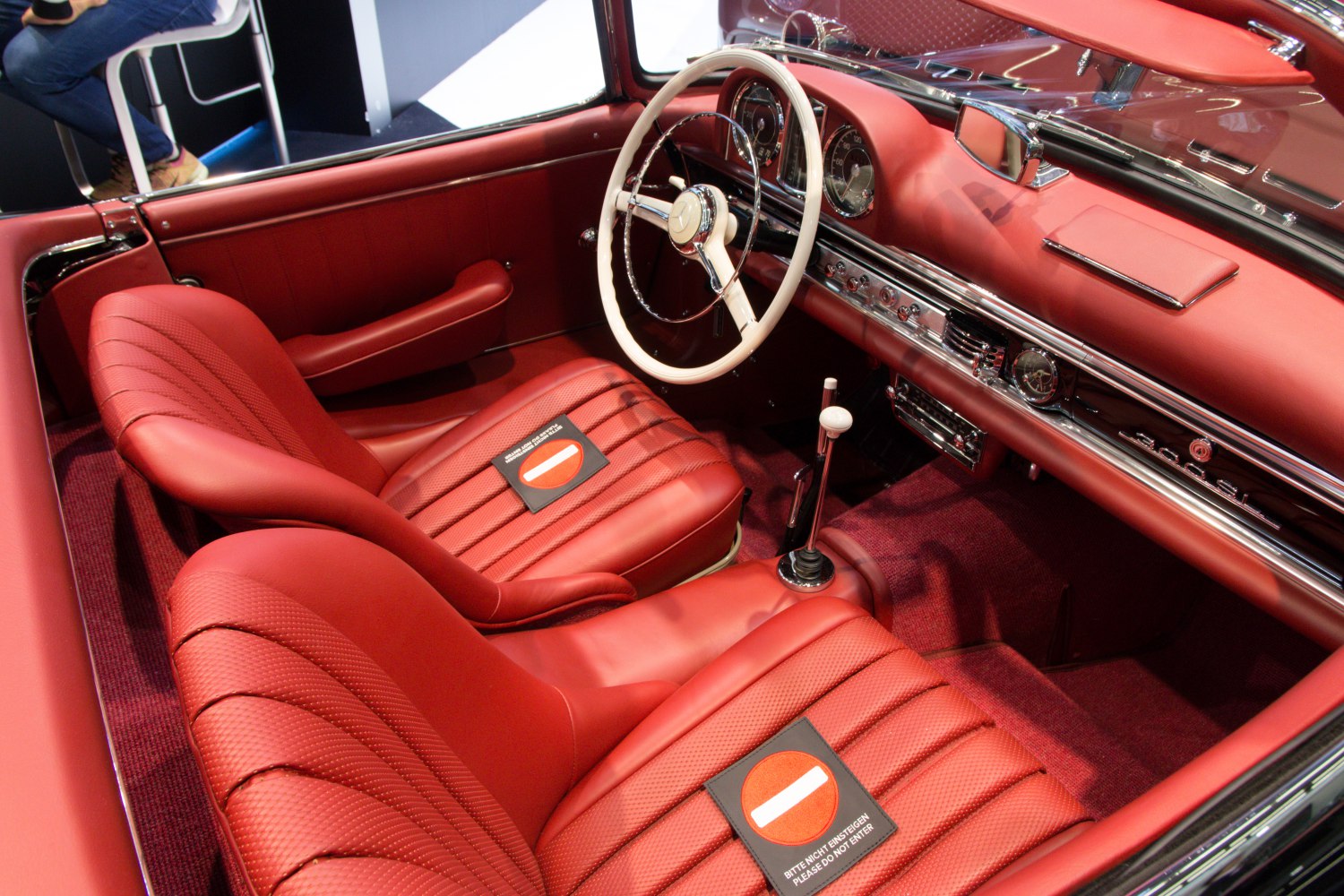 Red leather interior with white steering wheel and classic dashboard.