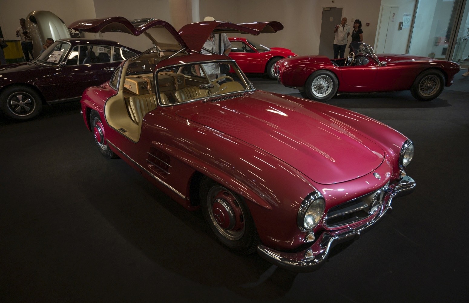 Gullwing doors open on vintage coupe with leather interior.