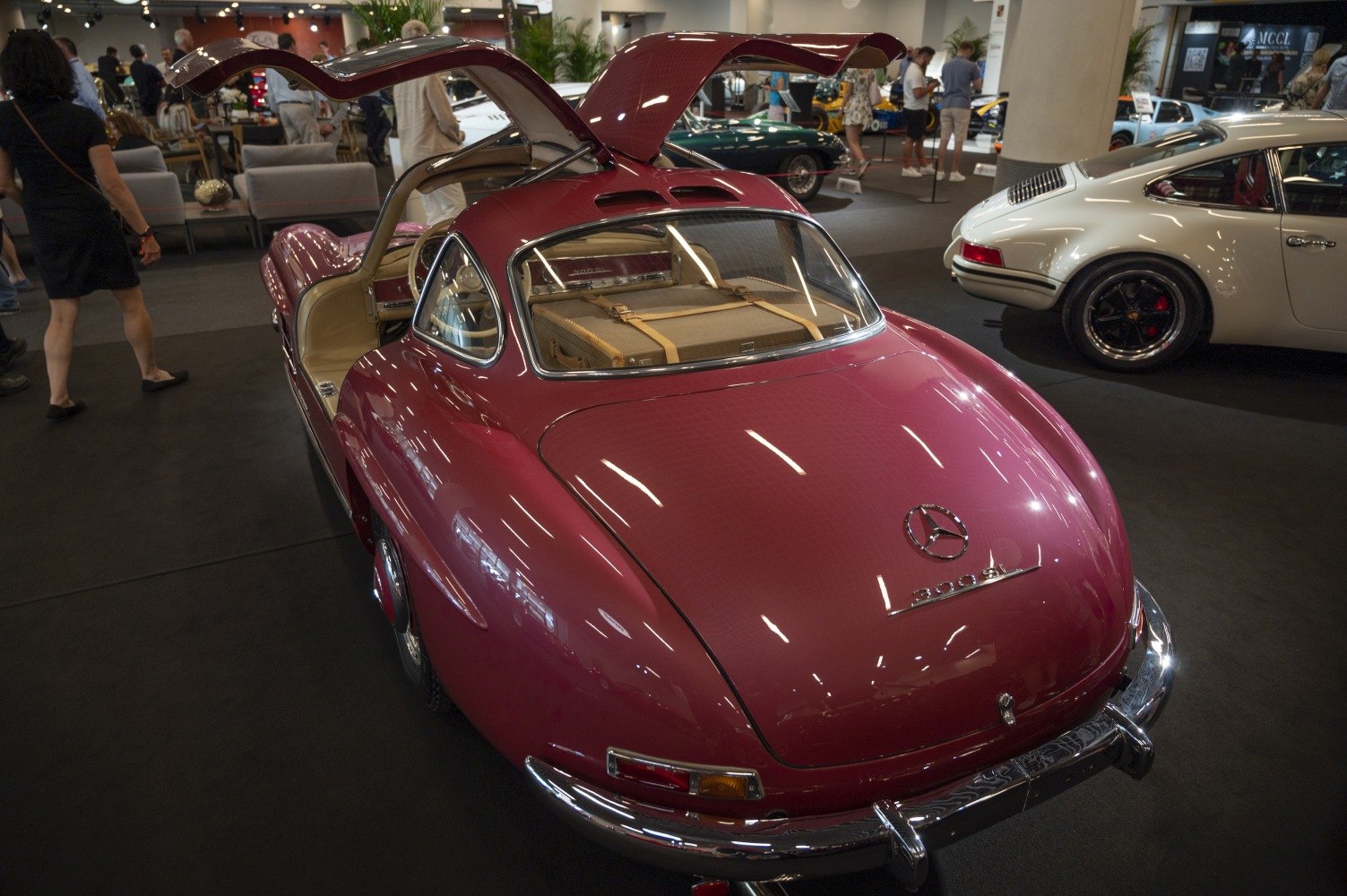 Gullwing doors open with a sleek rear view in a classic coupe.
