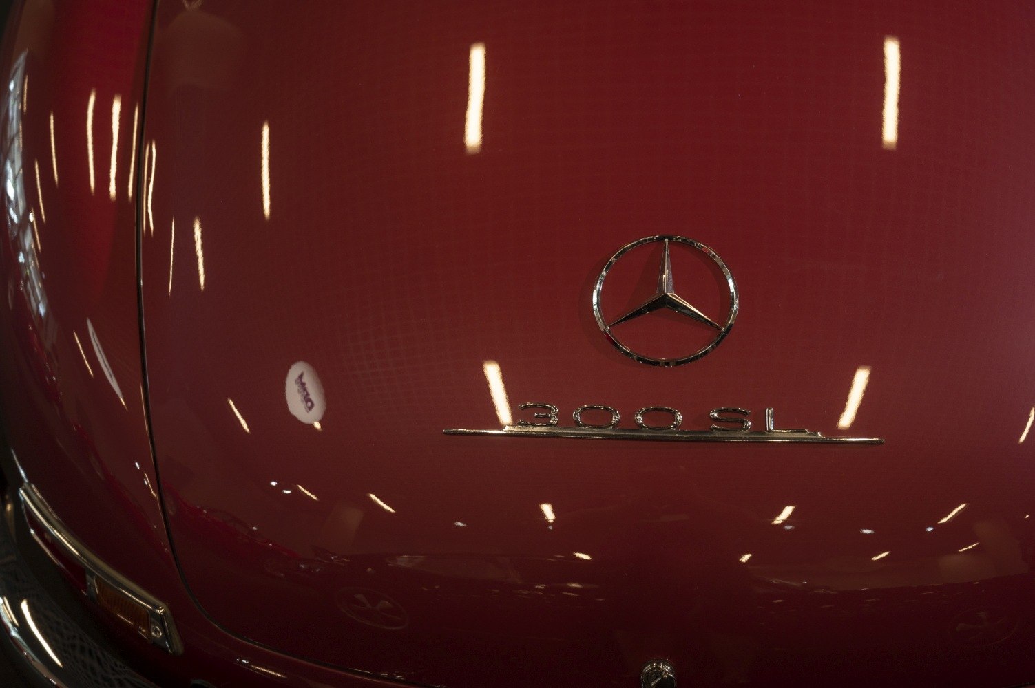 Close-up of 300SL emblem and badge on glossy red surface