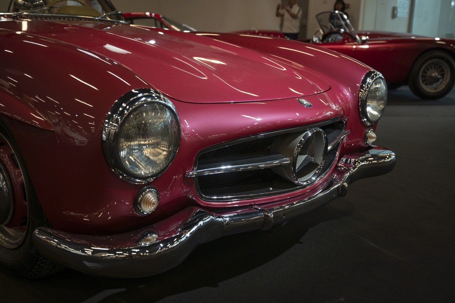Close-up of vintage car front grille and round headlights.