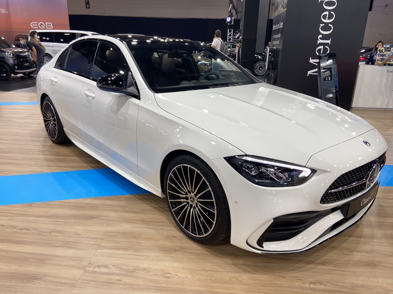 Front-side view of a white sedan with sporty alloy wheels and sleek LED headlights.