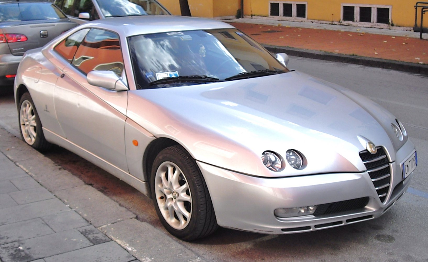 Silver coupe with dual round headlights and sporty alloy wheels